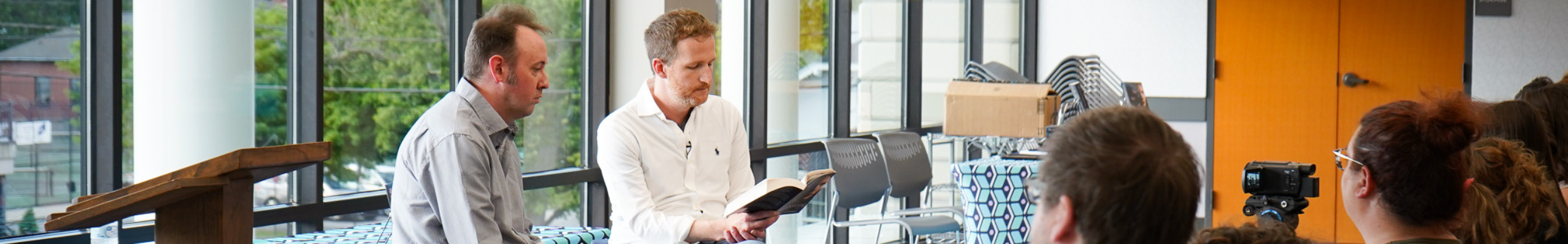 Adult header image showing an author reading to an audience