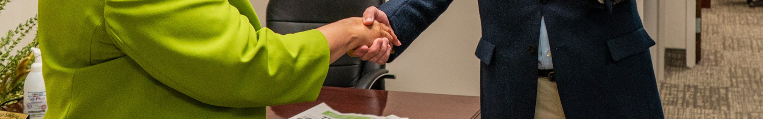 Board of Trustees header showing someone shaking hands with a trustee in a suit