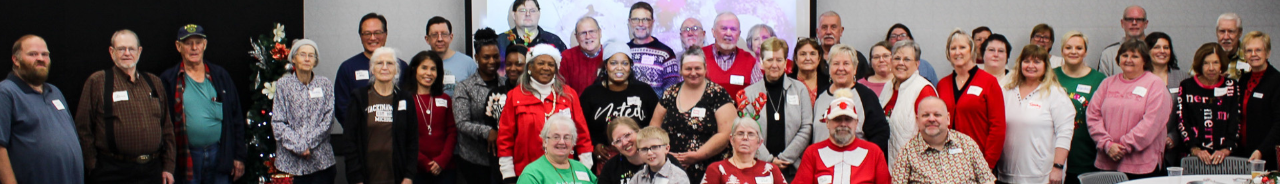 Genealogy and Local History header image depicting a group of librarians and patrons smiling at an event