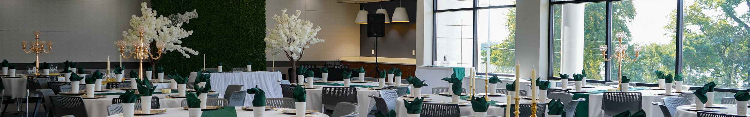 Large room with windows that is decorated for a wedding