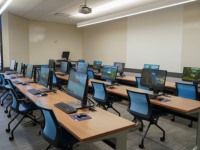 Rows of computers, tables, and chairs in a computer lab at the library