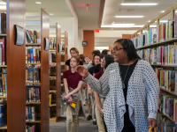 Woman leading a group of people through a library for a tour