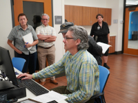 People standing around looking at a computer