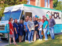 Group of people standing in front of the HCPL library bus