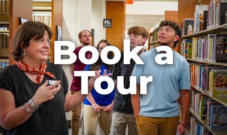 a photo of a group of teens getting a library tour from a librarian with their classmates and teacher